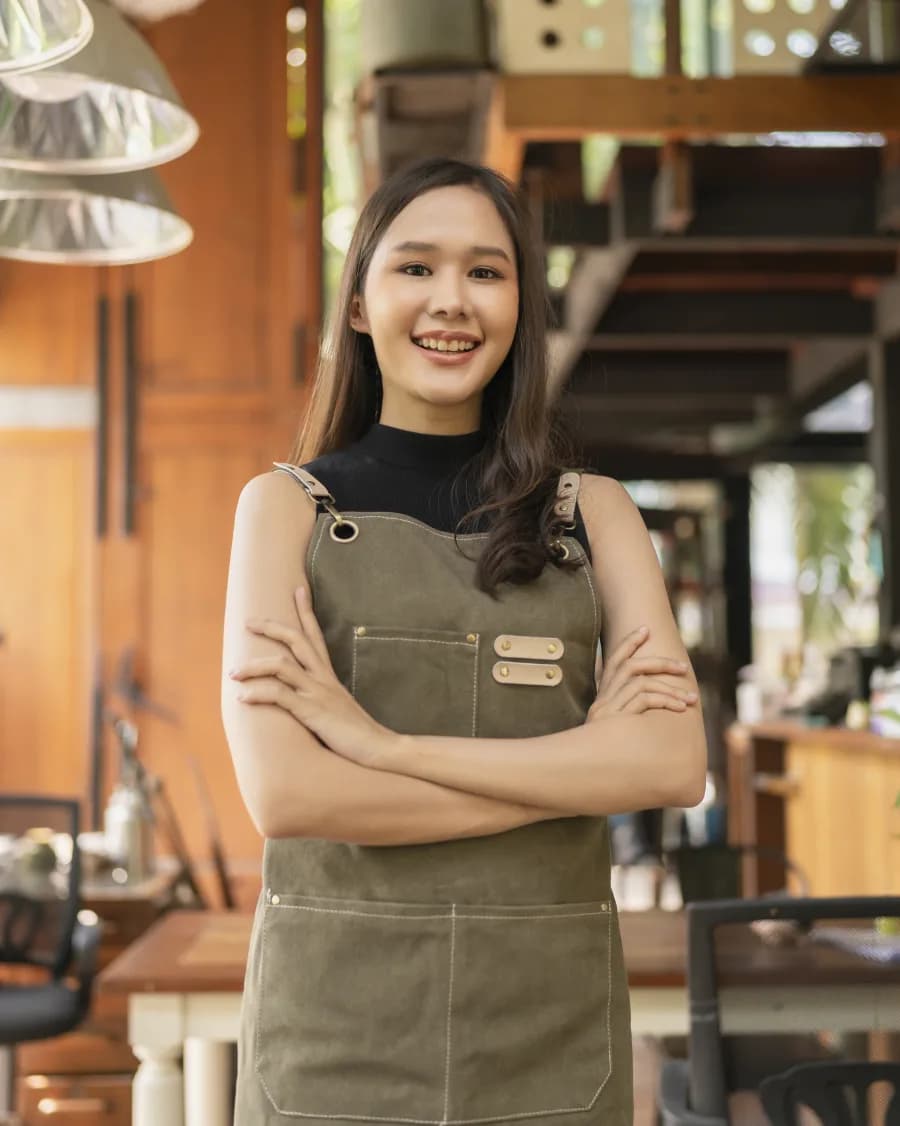 Smiling local cafe owner standing in her shop